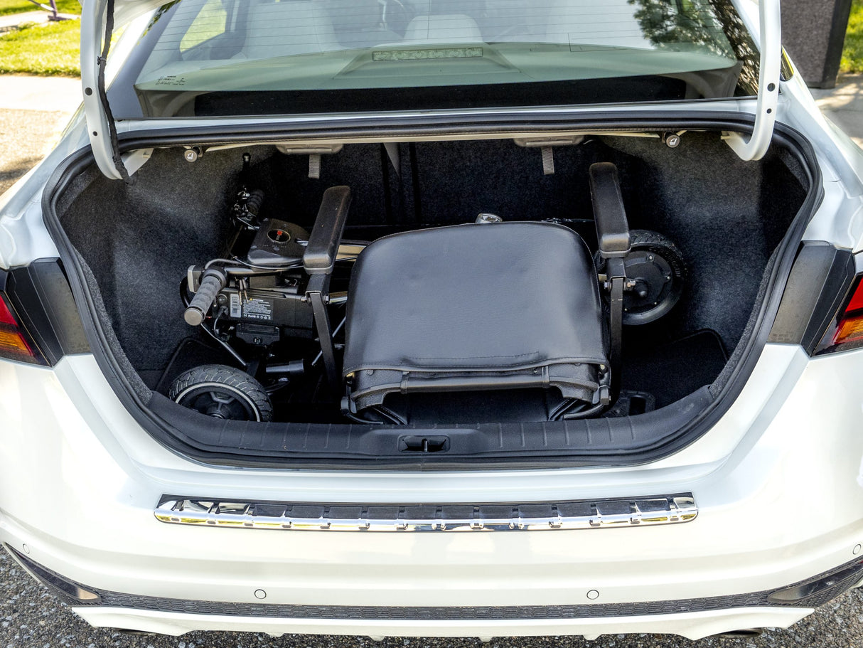 Foldable SNAPnGO mobility scooter stored in a car trunk – perfect for travel and portability