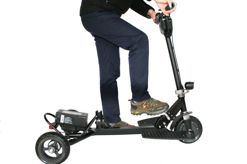 Adult man standing on SNAPnGO mobility scooter – demonstrating travel ease and portability